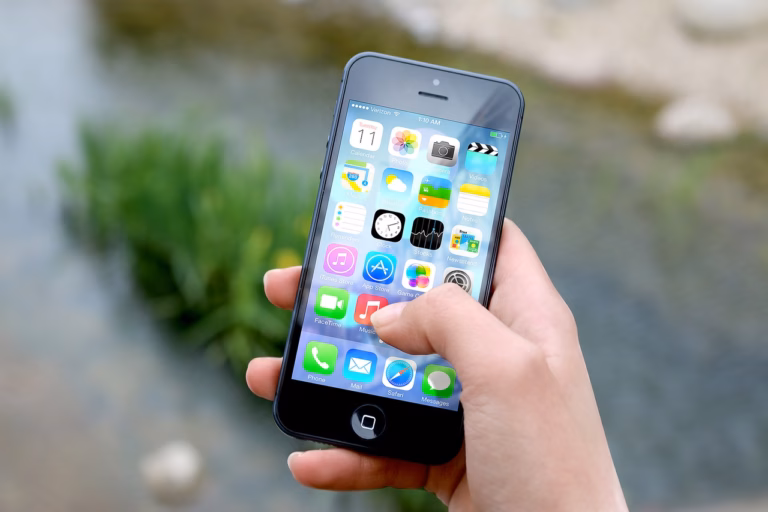 Hand holding phone showing mobile apps